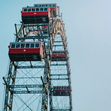Das Wiener Riesenrad mit seinen roten Kabinen vor dem blauen Himmel