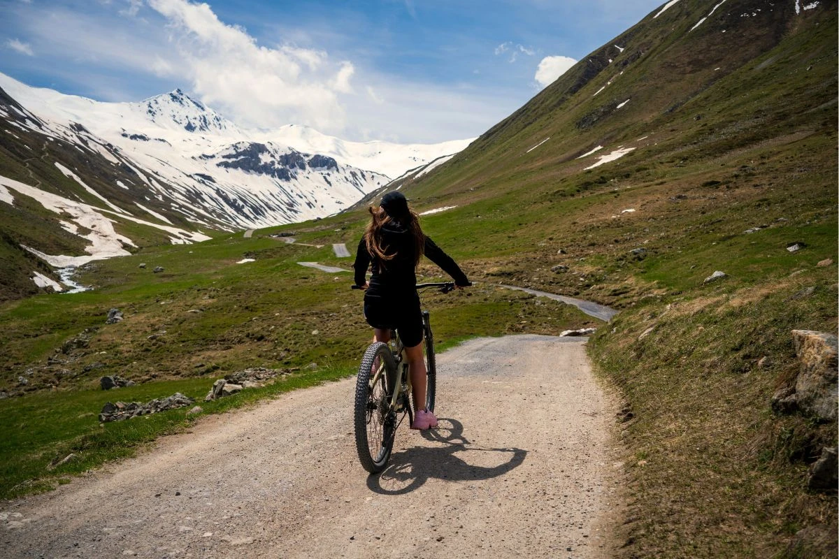 Radfahrerin vor spektakulärer Bergkulisse