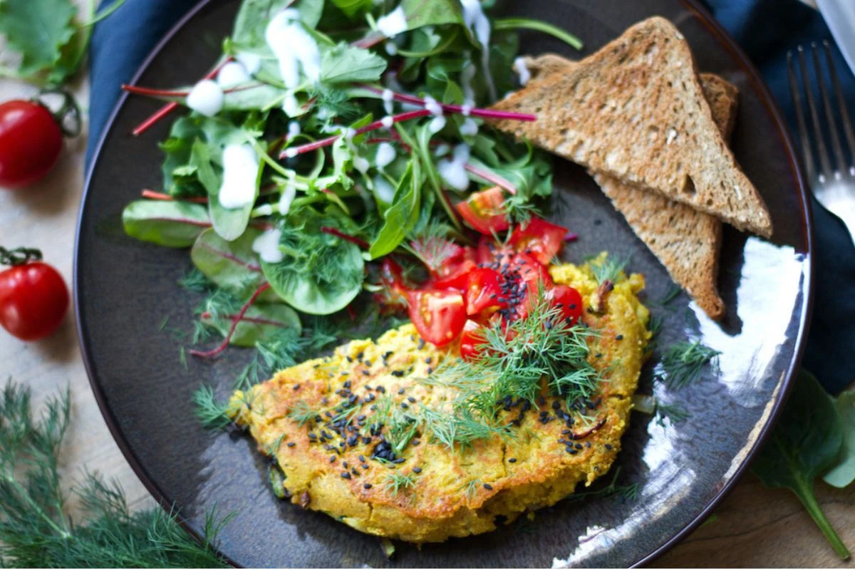 Veganes Omelett mit Salat und zwei Scheiben Toastbrot