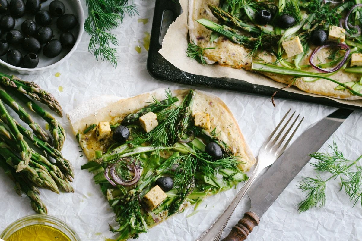 Flammkuchen mit Belag aus Spargel, Oliven und Dill