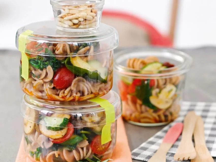 Mediterraner Nudelsalat in mehreren kleinen durchsichtigen Behältnissen.